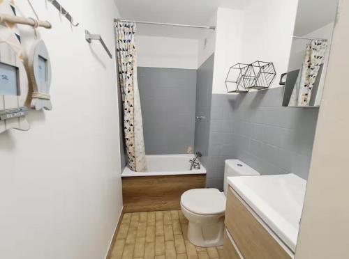 une salle de bain avec toilettes, baignoire et lavabo dans l'établissement Le confort près de la plage, au Grau-du-Roi