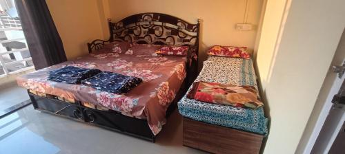 a bedroom with a bed and a twin bed with a bench at B-5 Sea Vista Apartment Dream Home in Ratnagiri