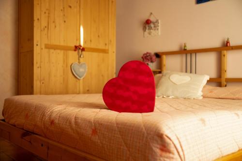 a red heart sitting on top of a bed at Agriturismo Spigolo in Avesa