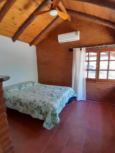 a bedroom with a bed in a room at Cabañas Franca Austral in Santa Rosa de Calamuchita