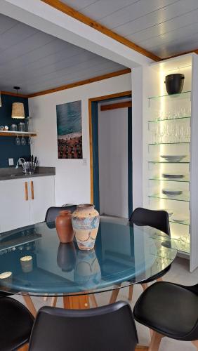 a dining room with a glass table and chairs at Casa CRETA - Hermenegildo in Santa Vitória do Palmar