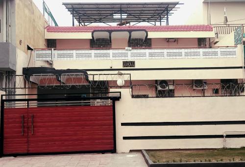 - un bâtiment avec une porte rouge et un balcon dans l'établissement New Palace Guest House, à Islamabad