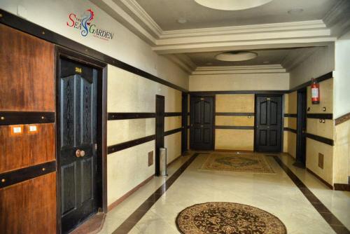 a hallway with many doors and a rug on the floor at La mer Hotel in Alexandria