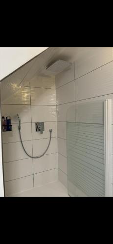 a bathroom with a shower with a hose on the wall at Ferienwohnung am Bürgerpark in Bremerhaven