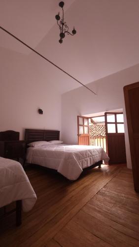 a bedroom with two beds and a window at Antuquita's House in Cusco