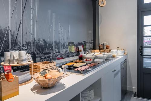a buffet with food on a table with boats on the wall at ibis Styles Vannes Gare Centre in Vannes