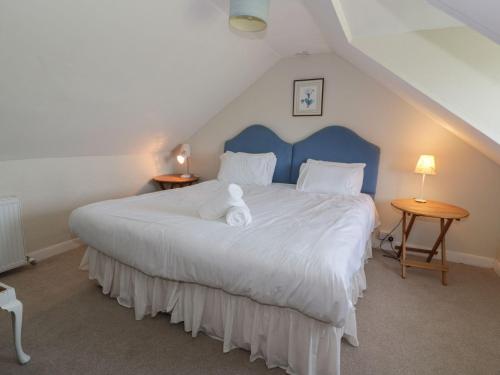 a bedroom with a large bed with a blue headboard at Powillimount Cottage in Dumfries