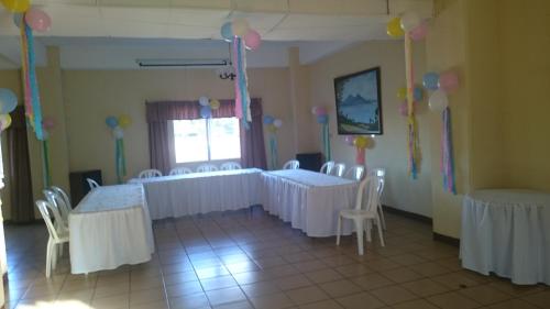 a room with white tables and chairs and balloons at Hotel Sevilla in Guatemala