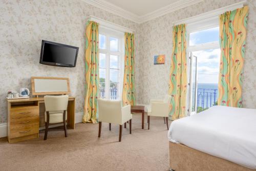 a bedroom with a bed and a desk and a television at The Esplanade Hotel in Scarborough