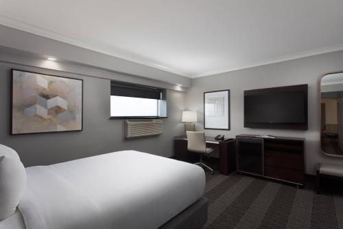 a hotel room with a bed and a desk and a television at Hotel Duval, Autograph Collection in Tallahassee