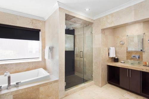 a bathroom with a tub and a glass shower at Hotel Duval, Autograph Collection in Tallahassee