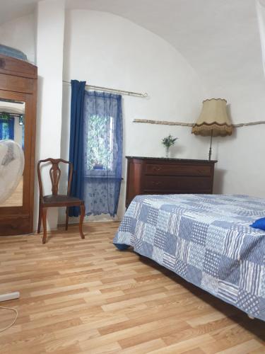 ein Schlafzimmer mit einem Bett, einem Stuhl und einem Fenster in der Unterkunft Casa di ingrida Bussana Vecchia in Sanremo