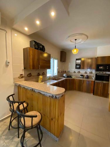 a kitchen with a counter and two chairs in it at HÉBERGEMENT Sahnoun in Mostaganem