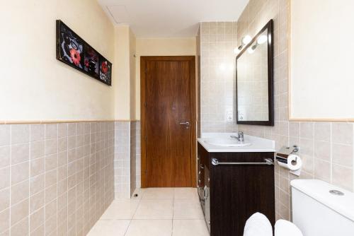 a bathroom with a sink and a wooden door at Villa Pla de l Era in Salou