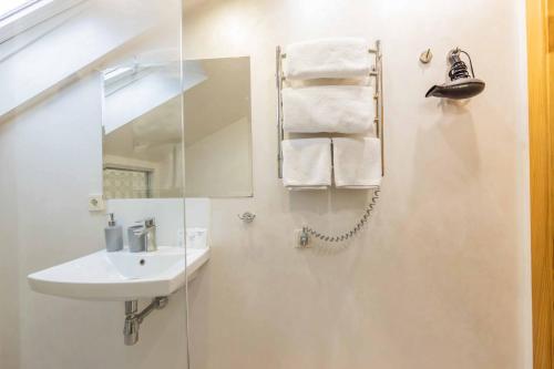 a white bathroom with a sink and a mirror at CityApartments Kyiv Maidan in Kyiv