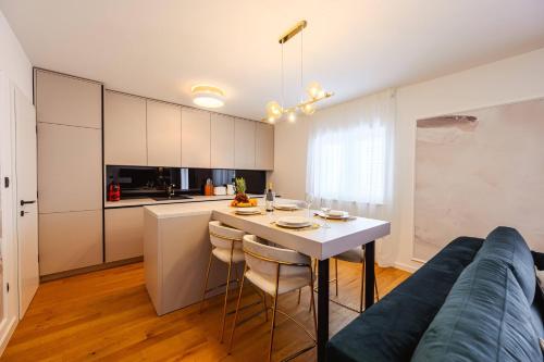 a kitchen and living room with a table and a couch at 1st choice - spa apartment in Metković