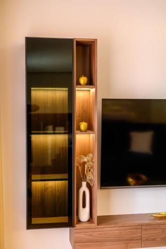 a wooden cabinet with a tv on a wall at 1st choice - spa apartment in Metković