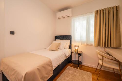 a bedroom with a bed and a desk and a window at 1st choice - spa apartment in Metković