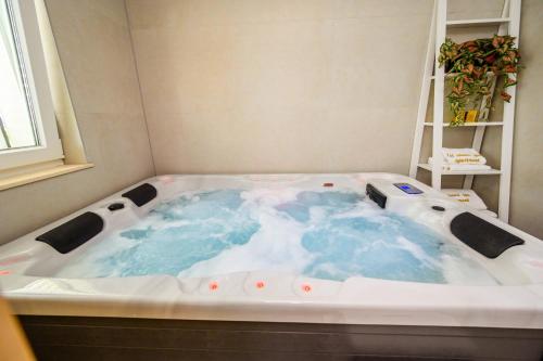 a jacuzzi tub in a corner of a room at 1st choice - spa apartment in Metković