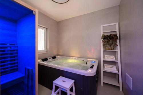 a bathroom with a large tub with a stool in it at 1st choice - spa apartment in Metković