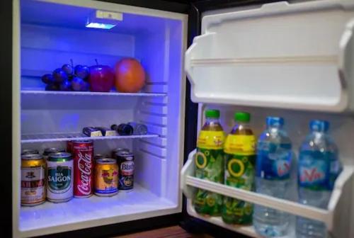 an open refrigerator filled with soda and drinks at TUAN Central Hotel in Hanoi