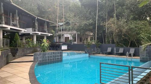 a large swimming pool in front of a building at B'camp Resorts & Homestays in Wayanad