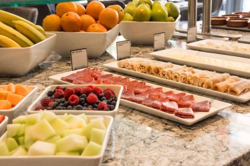 a buffet filled with different types of fruit on a counter at AC Hotel by Marriott Boston Cleveland Circle in Boston