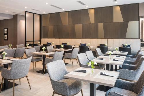 a dining room with tables and chairs at AC Hotel by Marriott Boston Cleveland Circle in Boston