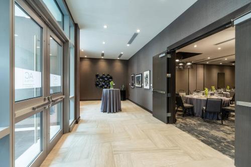 a dining room with tables and chairs and windows at AC Hotel by Marriott Boston Cleveland Circle in Boston