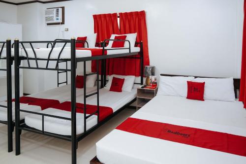 two bunk beds in a room with red accents at RedDoorz Plus at Billy's Resort Oslob in Oslob