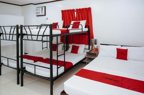 a room with two bunk beds with red accents at RedDoorz Plus at Billy's Resort Oslob in Oslob