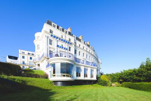 a large white building sitting on top of a lush green field at The Esplanade Hotel in Scarborough