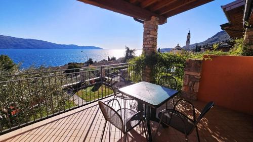 a balcony with a table and chairs and a view of the water at Residence Borgo Dei Limoni - Appartamenti con Garage in Gargnano