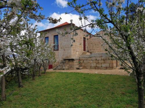 a brick house with trees in front of it at Solar dos Condes da Azenha in Fonte Arcada
