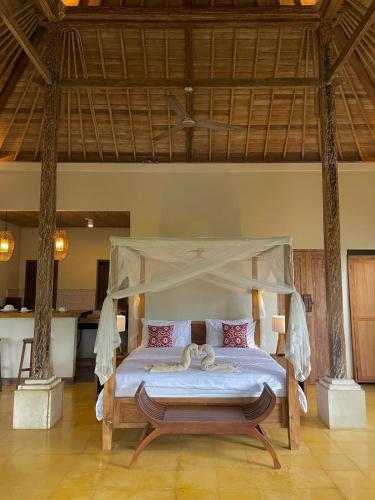 a bedroom with a bed with a canopy at Thani Villa Ubud in Ubud