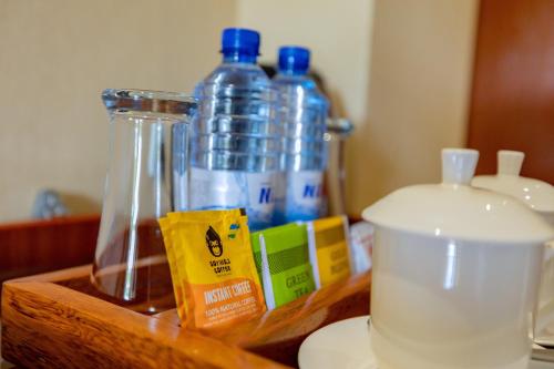 a wooden counter with bottles of water and a blender at M Hotel Kigali in Kigali