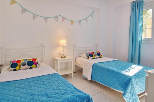 2 Betten in einem blau-weißen Zimmer in der Unterkunft Villa Nefeli Periyali in Vasilikos