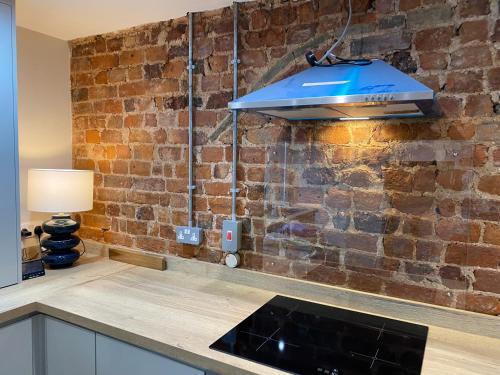 a kitchen with a brick wall and a blue overhead light at Newly Designed Home from Home in Retford in Retford