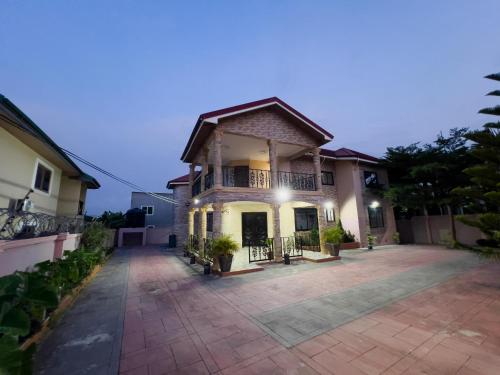 a house with a driveway in front of it at Branch-Lina in Amasaman