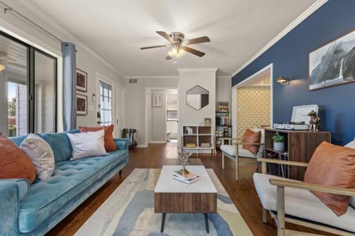 a living room with a blue couch and a ceiling fan at Tulsa Expo Firepit Midtown House in Tulsa