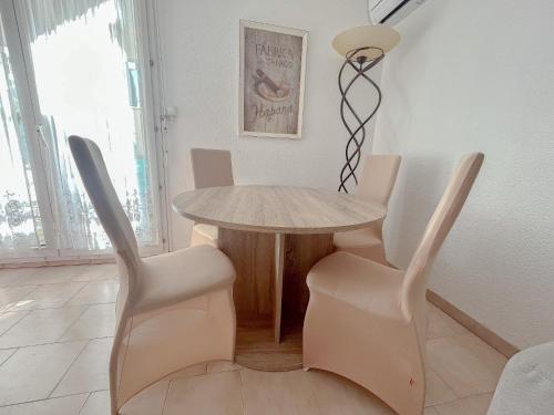 une salle à manger avec une table et deux chaises dans l'établissement Central avec jardin, piscine parking 150 m plage, Fréjus, à Fréjus