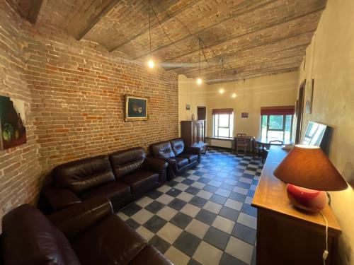 a living room with a couch and a brick wall at La Ferme Saint Pierre de Glabais in Genappe