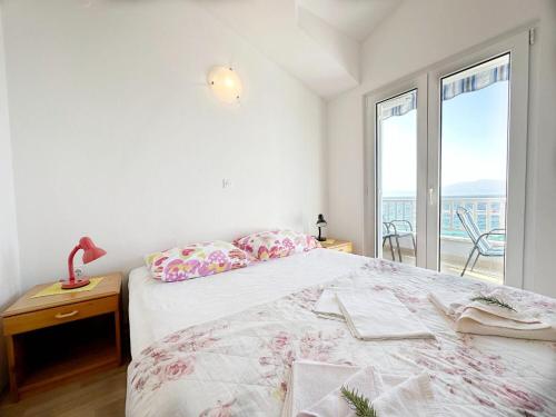 een slaapkamer met een bed met uitzicht op de oceaan bij Apartments Tomo in Zaostrog