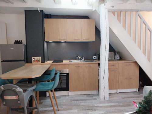 une cuisine avec des armoires en bois et une table avec des chaises dans l'établissement Duplex familial 2 chambres Disney Paris CDG, à Annet-sur-Marne