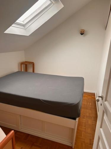 a bed in a room with a skylight at Maison de ville arborée avec cachet in Nanterre