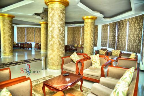 a living room with chairs and a table and columns at La mer Hotel in Alexandria