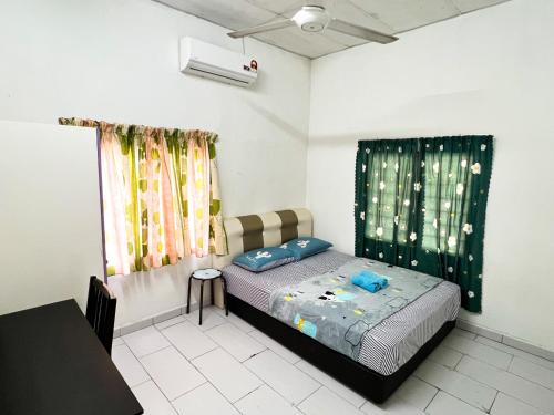 a small bedroom with a bed and a table at Padang Besar White House Homestay in Padang Besar