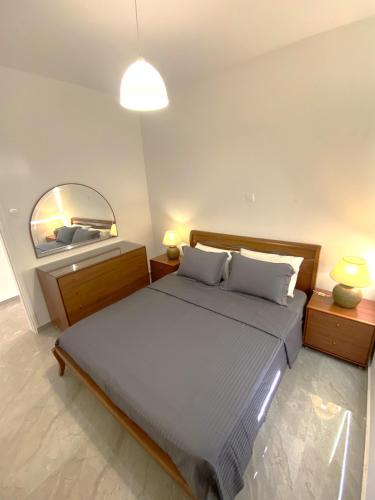 a bedroom with a large bed and a mirror at Mediterranean Apartments 2 in Paphos
