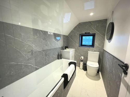 une salle de bain avec baignoire et toilettes dans l'établissement Pass the Keys Beautifully Presented Cosy Town Centre Cottage, à Dumfries