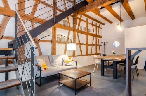 a living room with a staircase and a table at Apartments im Gästehaus Krone in Bodman-Ludwigshafen